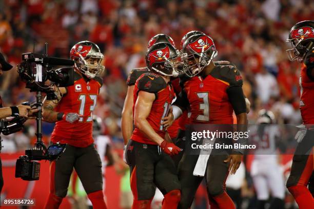 Quarterback Jameis Winston of the Tampa Bay Buccaneers runs in to celebrate in the end zone with wide receiver Adam Humphries after connecting with...