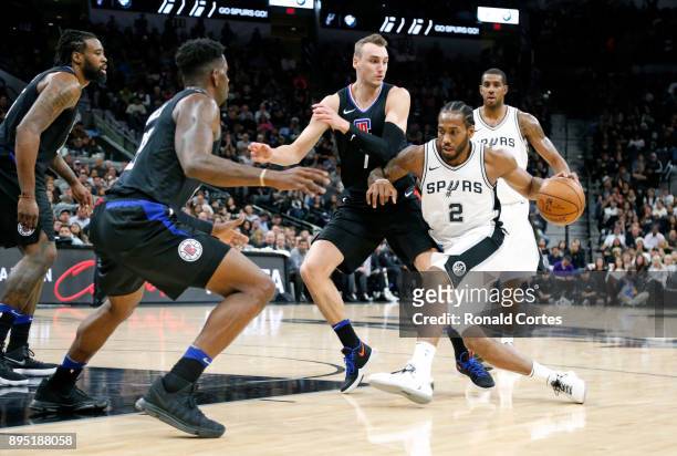 Kawhi Leonard of the San Antonio Spurs tries to drive on Sam Dekker of the Los Angeles Clippersat AT&T Center on December 18, 2017 in San Antonio,...