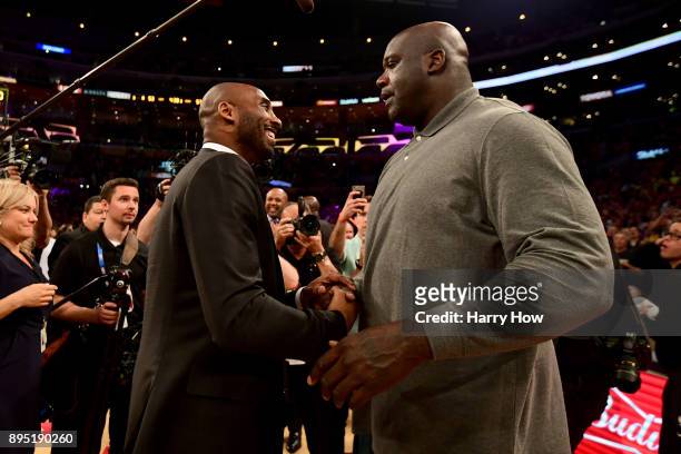 Kobe Bryant and Shaquille O'Neal shake hands at halftime after both of Bryant's and Los Angeles Lakers jerseys are retired at Staples Center on...