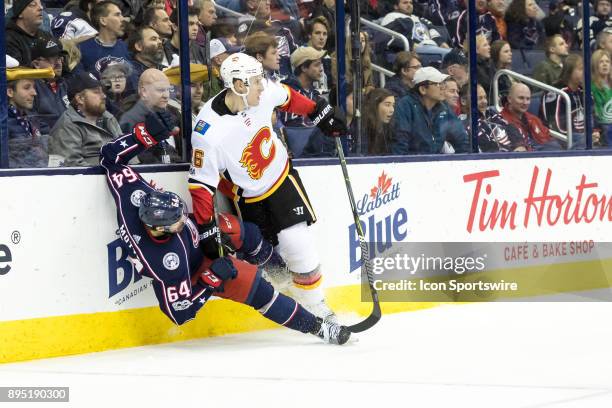 Calgary Flames defenseman Michael Stone checks Columbus Blue Jackets center Tyler Motte along the glass in the third period of a game between the...