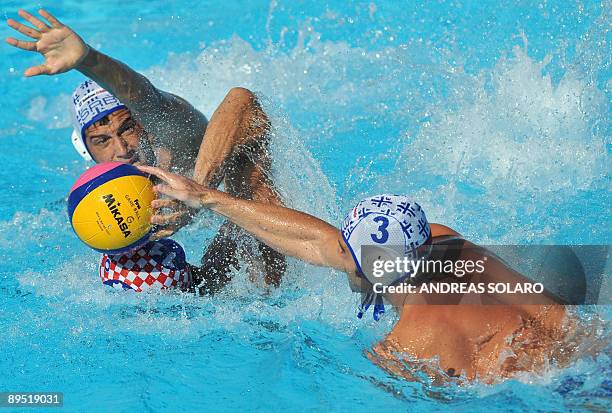 Croatian Igor Hinic fights for the ball with Serbian Zivko Gocic and Vanja Udovicic during the water-polo men semi-final, on July 30, 2009 at the...