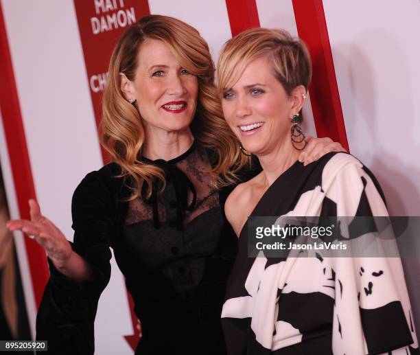 Actresses Laura Dern and Kristen Wiig attend the premiere of "Downsizing" at Regency Village Theatre on December 18, 2017 in Westwood, California.