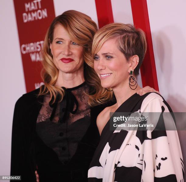 Actresses Laura Dern and Kristen Wiig attend the premiere of "Downsizing" at Regency Village Theatre on December 18, 2017 in Westwood, California.