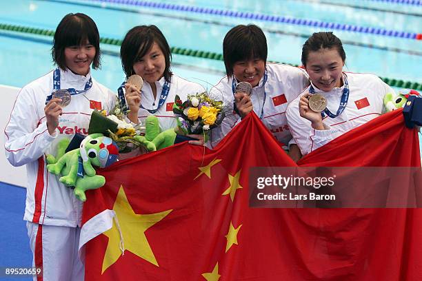 Yu Yang, Qian Zhu, Jing Liu and Jiaying Pang of China receive the gold medal during the medal ceremony for the Women's 4x 200m Freestyle Final during...