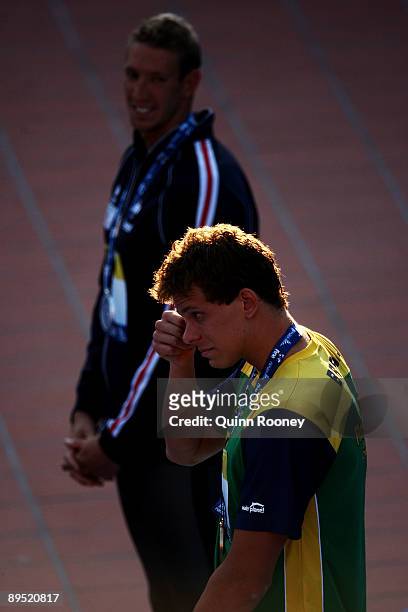 Cesar Cielo Filho of Brazil is emotional as Alain Bernard of France looks on as he receives the gold medal during the medal ceremony for the Men's...