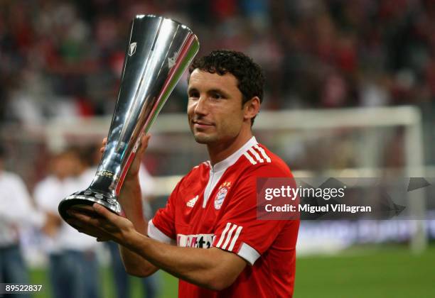 Mark van Bommel of Muenchen holds the trophy after winning the Audi Cup tournament final match between FC Bayern Muenchen v Manchester United at...