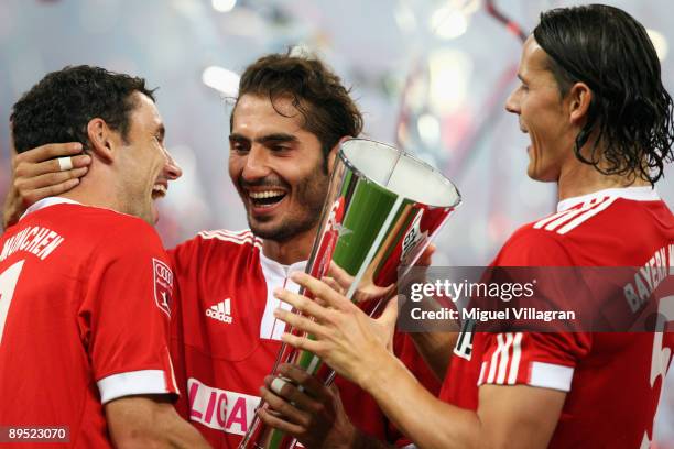Mark van Bommel, Hamit Altintop and Daniel van Buyten of Munich hold the trophy after winning the Audi Cup tournament final match between FC Bayern...