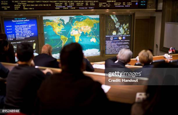 In this handout photo provided by NASA, Friends and family members of the Soyuz MS-07 crew watch a live view of the International Space Station, as...