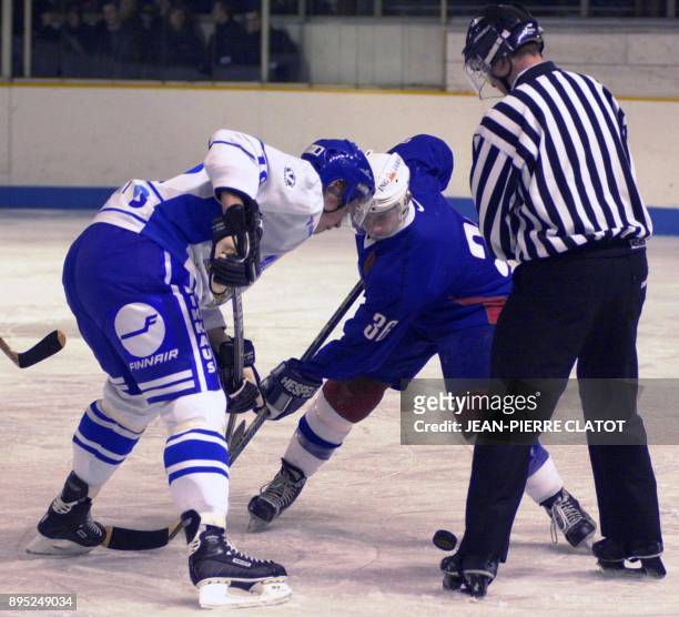 Le joueur de l'équipe de France de hockey, Richard Aimonetto , dispute le palet avec le joueur finlandais Mikka Lindholm, le 27 décembre 2001 à la...