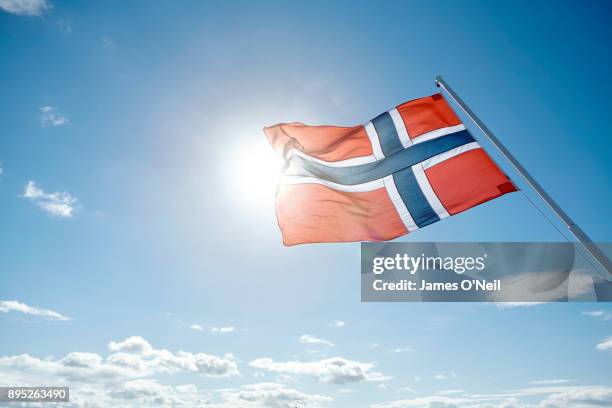 norwegian flag backlit by sun and blue sky, norway - norway flag stock pictures, royalty-free photos & images
