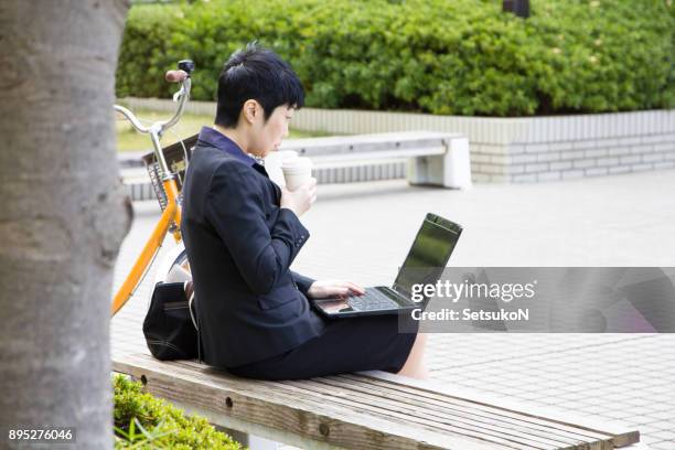 asiatische geschäftsfrau mit laptop in einem park - bank müde frühling stock-fotos und bilder