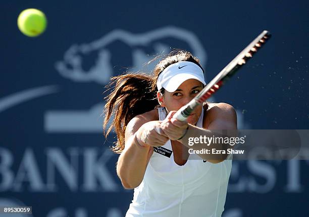 Marion Bartoli of France returns a shot to Melanie Oudin of the USA during their match on Day 4 of the Bank of the West Classic at Stanford...