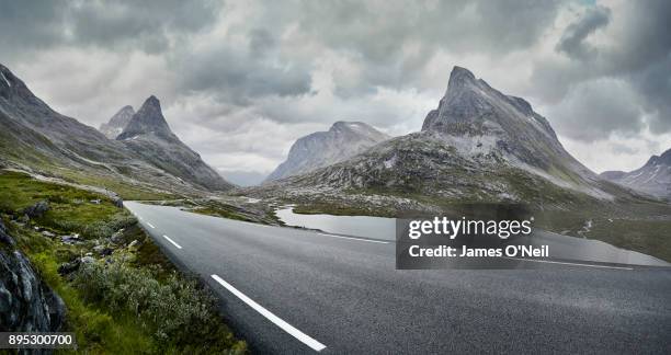 empty road through stormy mountain landscape, norway - norway landscape stock-fotos und bilder