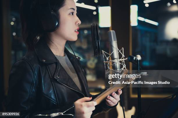 chica cantando y sostiene una tableta digital en un estudio de grabación, shanghai, china - micrófono de condensador fotografías e imágenes de stock