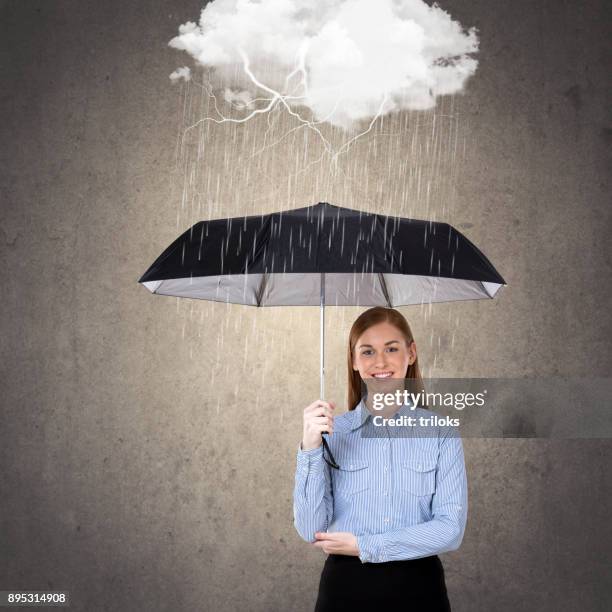businesswoman with umbrella under rain storm - lightning protection stock pictures, royalty-free photos & images