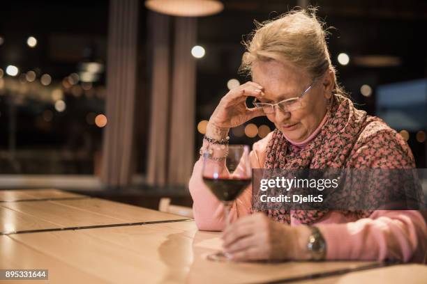 senior woman feeling depressed. - senior women wine stock pictures, royalty-free photos & images