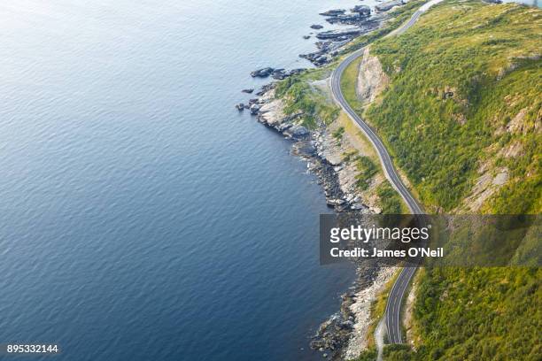 winding road next to ocean viewed from above, lofoten, norway - norway road stock pictures, royalty-free photos & images