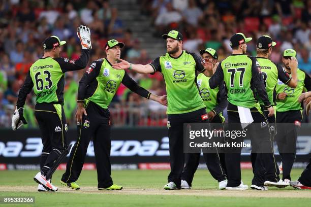 Mitch McClenaghan of the Thunder celebrates the run out of Sam Billings of the Sixers with his team mates during the Big Bash League match between...