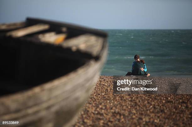 Couple relax on the beach on July 30, 2009 in Brighton, England. Britons have been put off going abroad on vacation due to the recession and are...