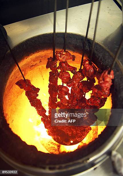 Skewers of chicken are roasted during the process of making Chicken Tikka Masala in the Shish Mahal restaurant in Glasgow, Scotland, on July 29,...