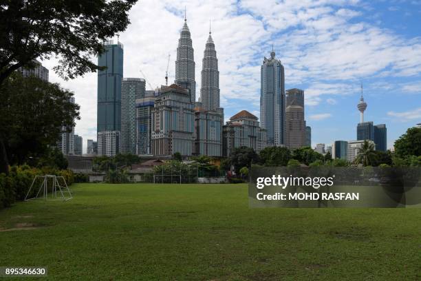 Football pitch is seen against the Kuala Lumpur city skyline with the landmark Petronas Twin Towers and Kuala Lumpur Tower in the distance, in...