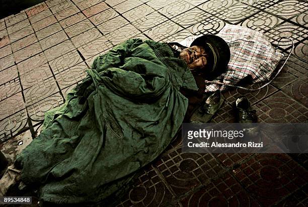 Homeless person sleeping on the street in Chongqing city center. The city of Chongqing is one of the fastest-growing urban centres on the planet. It...
