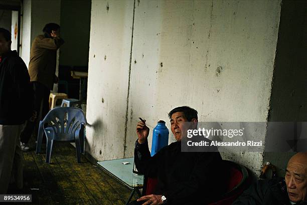 Man smoking inside a Chinese tea room in Chongqing. The city of Chongqing is one of the fastest-growing urban centres on the planet. It is changing...