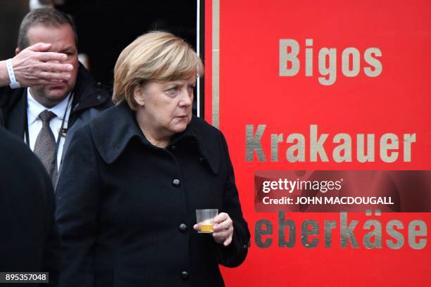 German Chancellor Angela Merkel holds a candle as she attends the inauguration of the memorial for the victims of the 2016 deadly truck attack at the...