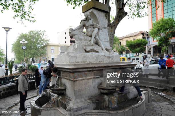 Picture taken on May 6, 2012 shows Algerians drinking from the fountain of Ain El Fouara in Setif, somme 300 kilometres east of the capital. -...