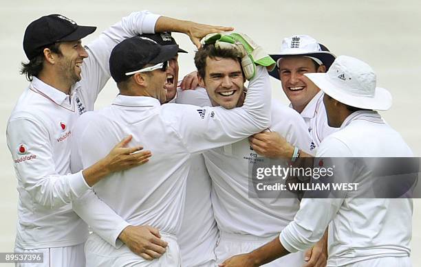 England paceman James Anderson celebrates with team-mates after dismissing Australian batsman Mitchell Johnson on the second day of the third Ashes...