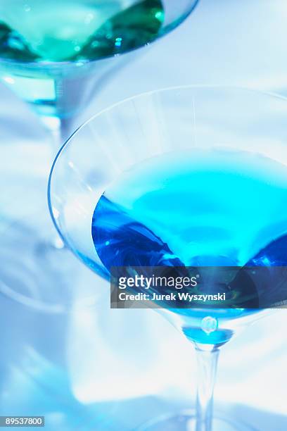 colorful martinis on watery background - blue martini glasses stock-fotos und bilder