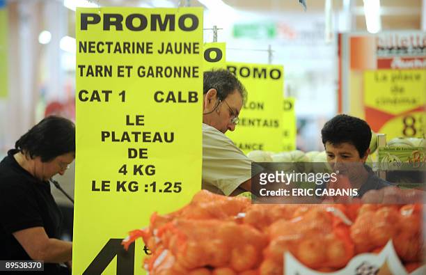 Des clients achètent des fruits, le 31 juillet 2009 dans une grande surface à Montauban, lors d'une "vente au déballage" organisée dans la galerie...
