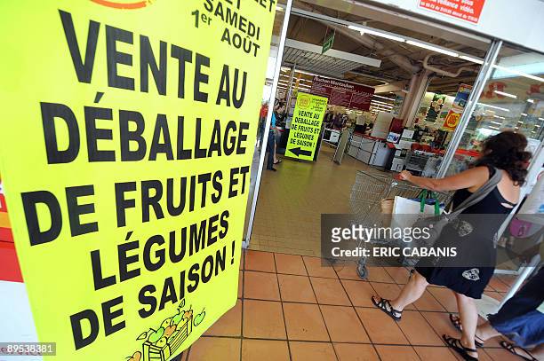 Des clients se rendent dans une grande surface, le 31 juillet 2009 à Montauban, alors qu'une affiche annonce une "vente au déballage". Créée par un...