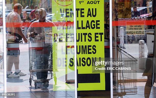 Des clients se rendent dans une grande surface, le 31 juillet 2009 à Montauban, alors qu'une affiche annonce une "vente au déballage". Créée par un...