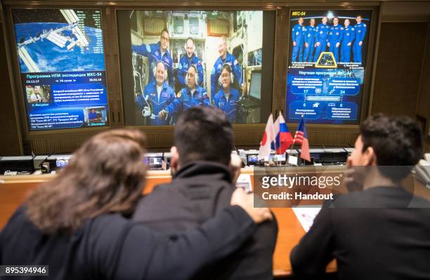 In this handout photo provided by NASA, Expedition 54 flight engineers Scott Tingle of NASA, bottom left, Anton Shkaplerov of Roscosmos, bottom...
