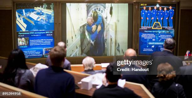In this handout photo provided by NASA, Scott Tingle of NASA is seen embracing Expedition 54 Commander Alexander Misurkin after the opening of the...