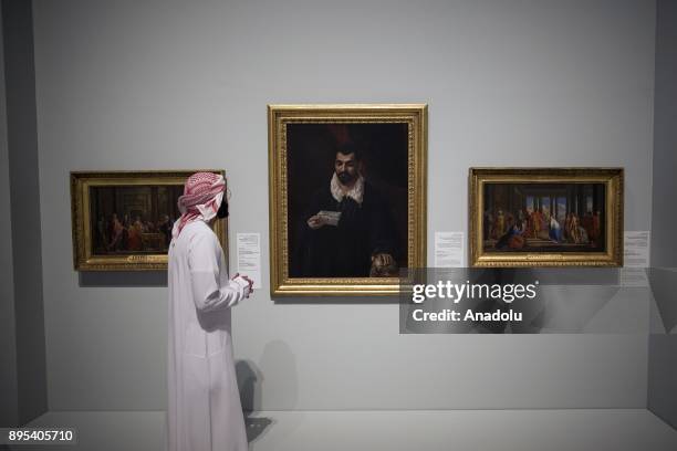 Visitor looks at the arts during the press preview of the "From One Louvre to Another" exhibition at the Louvre Abu Dhabi in Abu Dhabi, United Arab...