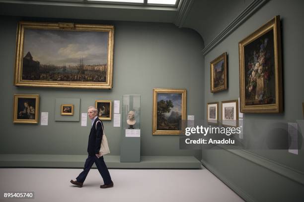 Visitor looks at the arts during the press preview of the "From One Louvre to Another" exhibition at the Louvre Abu Dhabi in Abu Dhabi, United Arab...