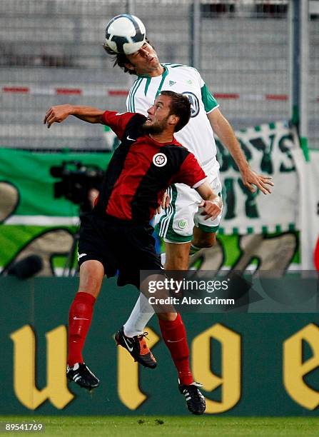 Andrea Barzagli of Wolfsburg jumps for a header with Marcel Ziemer of Wehen-Wiesbaden during the DFB Cup first round match between SV Wehen-Wiesbaden...