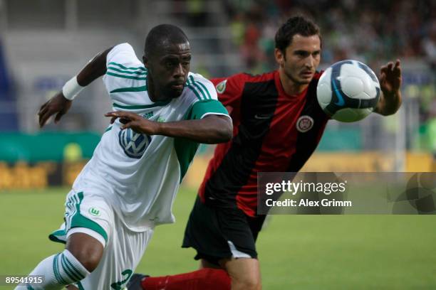 Grafite of Wolfsburg runs after the ball with Kristjan Glibo of Wehen-Wiesbaden during the DFB Cup first round match between SV Wehen-Wiesbaden and...