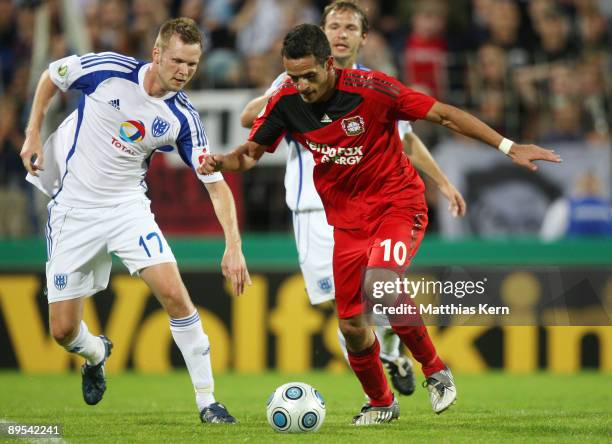 Renato Augusto of Leverkusen battles for the ball with Julian Prochnow of Potsdam during the DFB Cup first round match between SV Babelsberg 03 and...