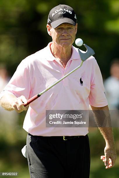 Tom Watson of the USA scoops his ball after making a practice putt on the 3rd hole during the second round of the 2009 U.S. Senior Open on July 31,...