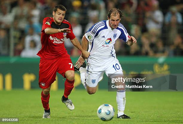 Tranquillo Barnetta of Leverkusen battles for the ball with Sven Hartwig of Potsdam during the DFB Cup first round match between SV Babelsberg 03 and...