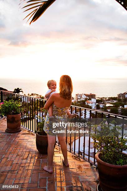 woman holding child outdoors - puerto vallarta stockfoto's en -beelden