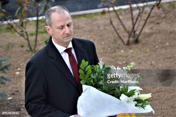 Man holds flowers in front of a statue of Russian Envoy Andrei Karlov during a commemoration on the first anniversary of his death at the Russian...