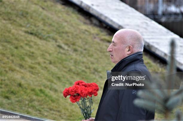 Man holds flowers during a commemoration of Russian Envoy Andrei Karlov on the first anniversary of his death at the Russian Embassy in Ankara,...