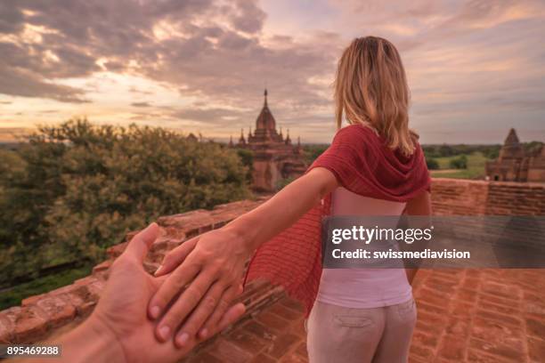 follow me to concept, woman leading boyfriend to bagan temples at sunrise, myanmar - follow me stock pictures, royalty-free photos & images