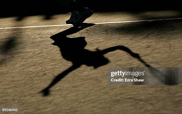 The shadow of Marion Bartoli of France is seen on the court while she serves to Jelena Jankovic of Serbia during their quarterfinal match on Day 5 of...