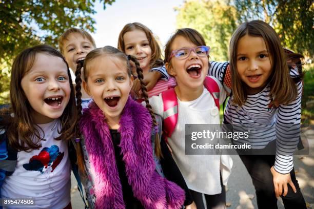 fröhliche kinder schreien außerhalb - erster schultag stock-fotos und bilder