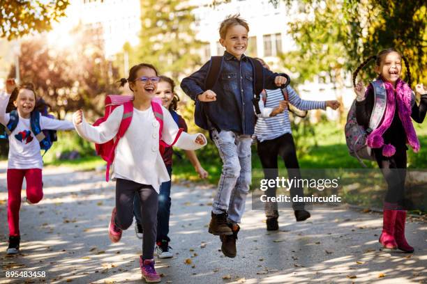 校庭で走っている学校の子供たち - 子供のみ ストックフォトと画像